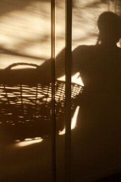 Shadow of woman holding wicker washing basket