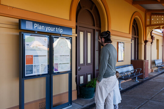 man looking at plan you trip sign at train statin platform in Armidale