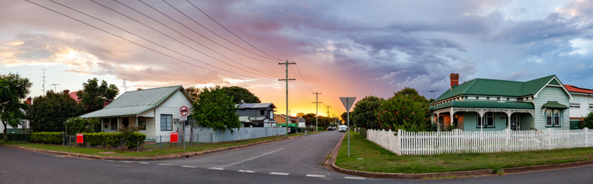 Dramatic sunset sky over weatherboard houses and t intersection road in Singleton