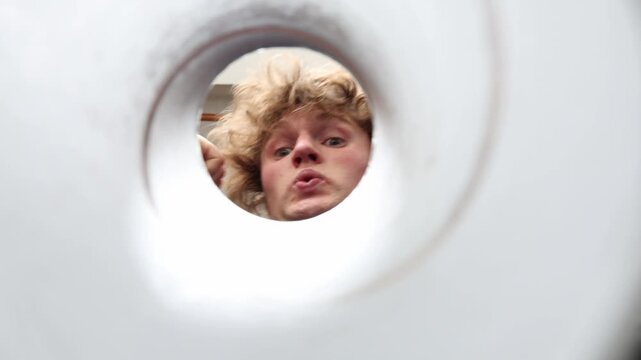 Person looks into an empty snack tube after finishing potato chips showing disappointment food cravings hunger and the search for one last bite of a favorite treat