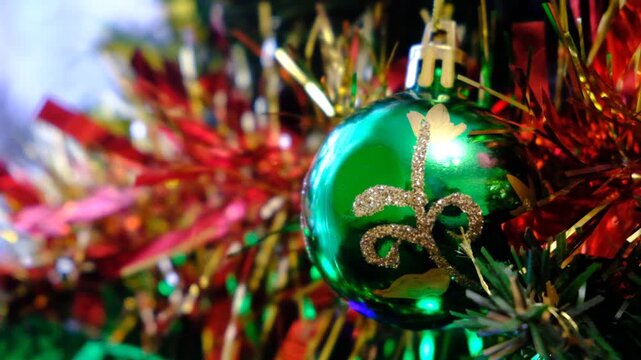 Close up a Christmas tree lights glittering at night. Festively decorations. Christmas tree branches with bright balls on blurred sparkling fairy background. White ball with space for text