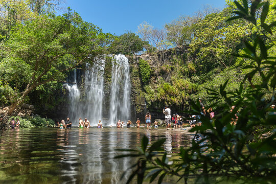 Tourists swimming at tropical waterfall in Costa Rica jungle