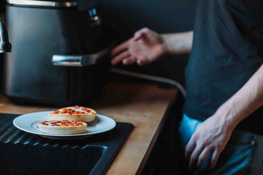 Person preparing mini pizzas in an air fryer at home