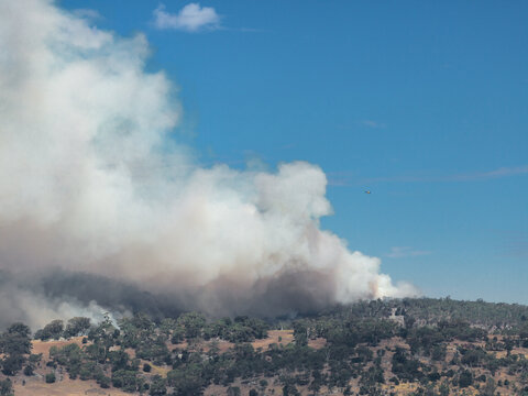 Aerial view of a large bushfire burning on a distant hillside