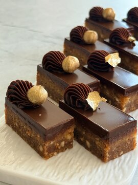 Luxury Chocolate Hazelnut Mignon Cakes with Edible Gold Leaf on White Plate