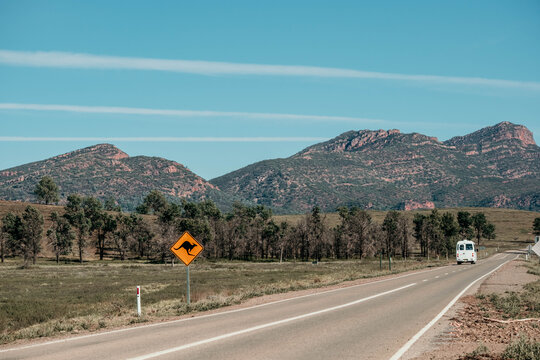 Tourist bus heading along the highway with mountain ranges in the background.