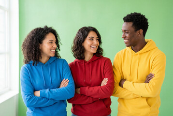 Obraz premium Happy diverse friends in colorful hoodies smiling