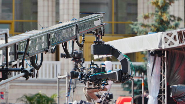 Professional video camera mounted on a large jib crane during a production
