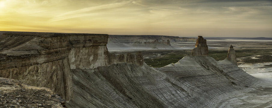 View of Bozzhyra View Point 1 featuring white limestone cliffs and unique rock formations under a golden sunset sky in Karakiya District, Mangystau Region, Kazakhstan.