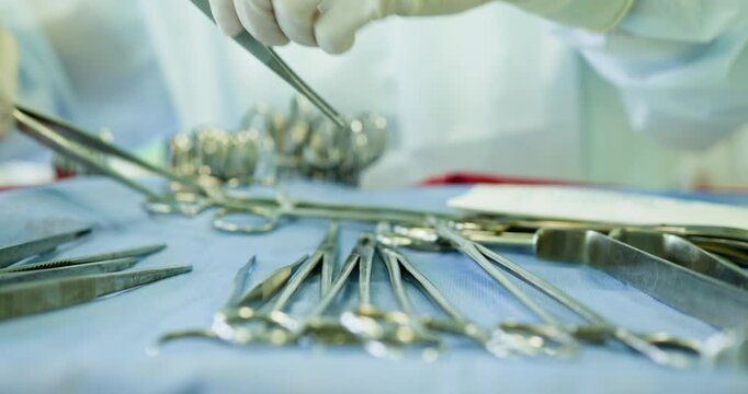 Healthcare professional organizing surgical instruments on sterile table for cleanliness and readiness. Healthcare Professionals Responsible for Handling and Managing Surgical Instruments Effectively