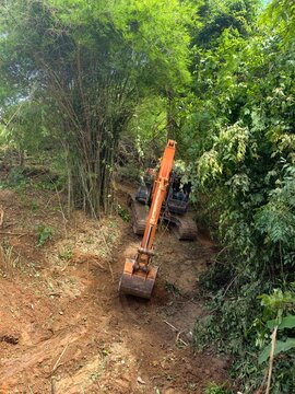 The backhoe is digging the ground.