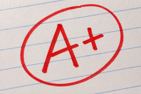 Red A plus grade circled on lined notebook paper symbolizing academic success and excellent school performance
