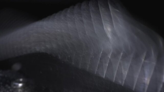A close-up shot of an electric razor blade in macro mode, revealing skin and hair particles. 200 frames of slow motion.