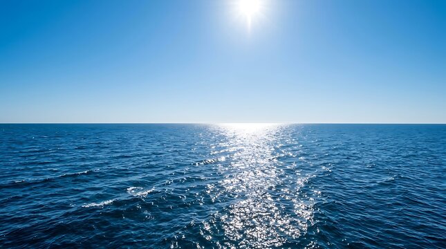 Sunlight reflecting on the calm blue surface of the ocean with a clear sky