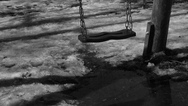 Park and swingings. Simple shot captures retro atmosphere, passage of time, subtle melancholy, vintage aesthetics, nostalgia. Deep long shadows, monochrome colors for strong visual storytelling