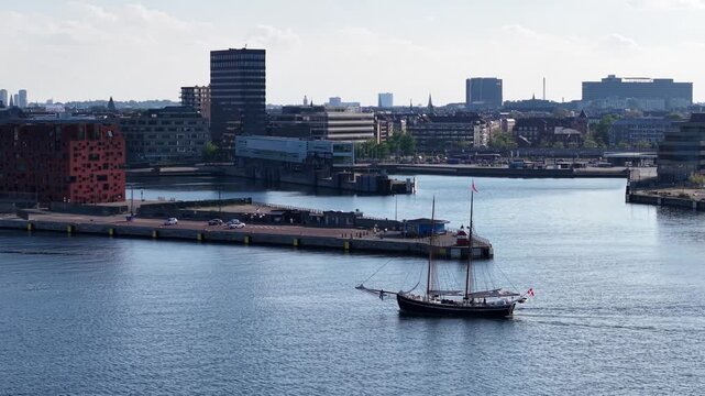 Drone shot of sailboat motoring through inner harbor canal, Copenhagen, Denmark