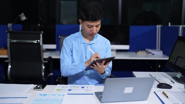 Young employee using computer working online, doing searching, taking notes, watching business training webinar in office, having virtual chat meeting looking at laptop at work.