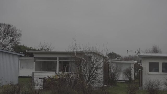 abandoned houses in a desolate landscape with an eerie, post-apocalyptic grey atmosphere. survival, isolation, urban decay and cinematic horror
