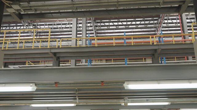 Dark industrial setting showcases gray steel structure with electric train warning signs and electrical fixtures for safety monitoring operations within controlled environment featuring advanced equip