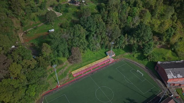 Aerial view of sports complex with soccer field, pool, and lush green surroundings