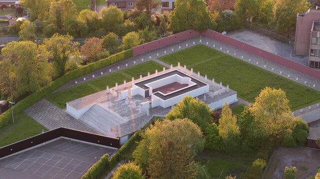 Aerial circling shot of Roman Temple replica during golden hour, Tongeren