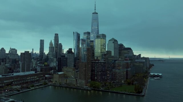 A breathtaking wide aerial shot of the Manhattan skyline, showcasing New York City's iconic collection of skyscrapers stretching across the horizon. The expansive perspective captures the scale, archi