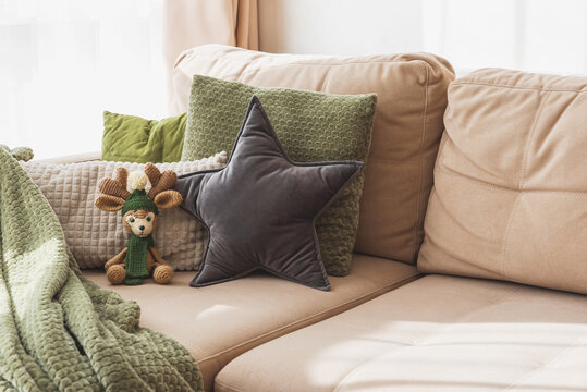 Cozy living room sofa with pillows and crochet deer plush toy