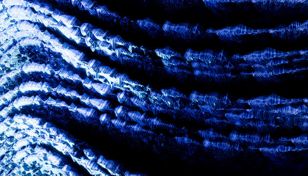 Abstract pattern of wavy blue lines creating a textured, rippling effect against a dark background.