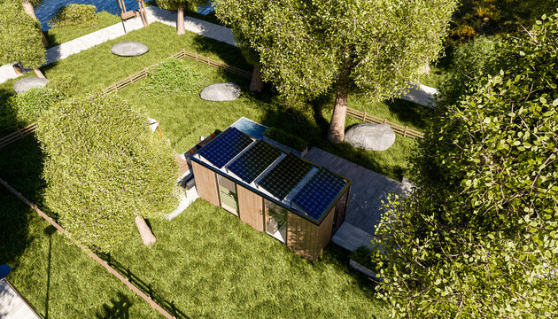 Modern tiny house with solar panels surrounded by lush green trees and grass.