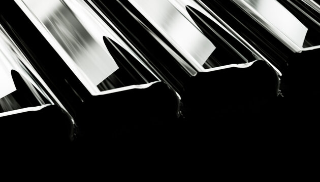 Close-up view of reflective metal beams in black and white highlighting geometric lines.