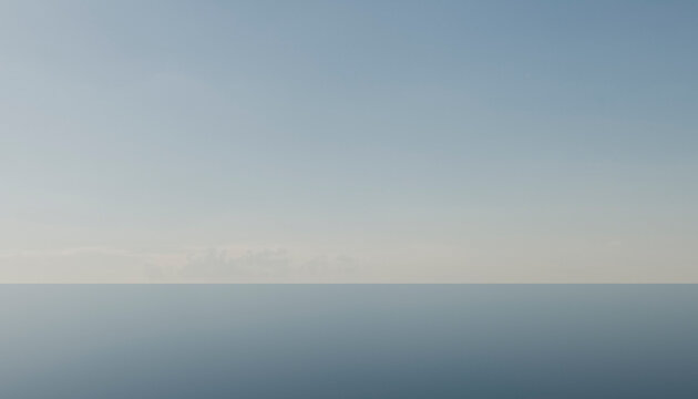 Serene horizon dividing a clear blue sky and calm sea under soft daylight.