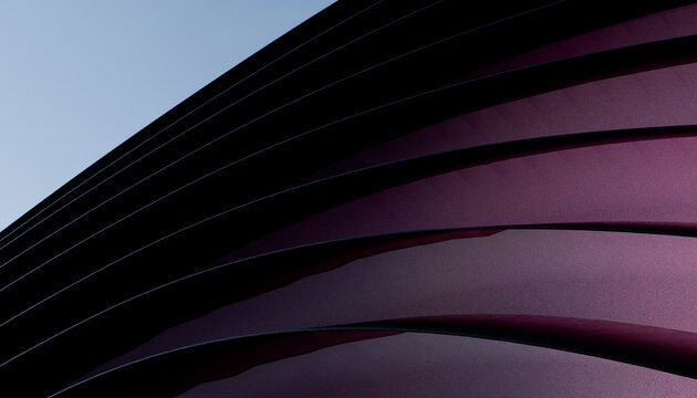 Curved abstract architectural structure with sleek purple and black lines against a clear sky.
