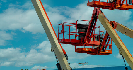 Articulated boom lift. Aerial platform lift. Telescopic boom lift against blue sky. Mobile construction crane for rent. Repair hydraulic boom lift service. Crane dealership. Safety use of machinery. © Fahroni