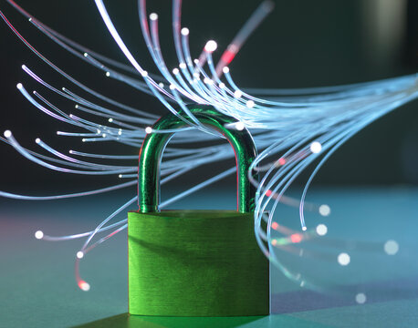 Green padlock surrounded by glowing fiber optic cables on a reflective surface.
