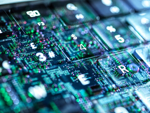 Close-up of a backlit keyboard with a circuit board design overlay.