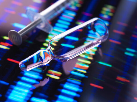 A syringe and ampoule on a colorful DNA sequencing background with vibrant light effects.
