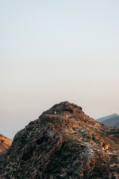 Majestic rocky mountain peak under a soft, warm sky during sunrise or sunset.