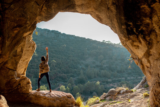 girl with a backpack. A woman with a backpack stands in a cave. The girl explores the cave. Tour of the cave.