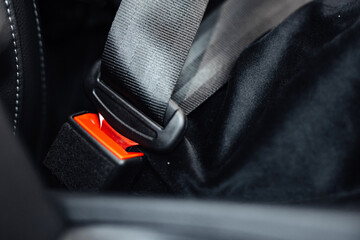 car seat belt. Close up of a car seatbelt buckle with a red release button secured in a vehicle interior, showcasing the safety feature and design elements of automotive seating. © Luis