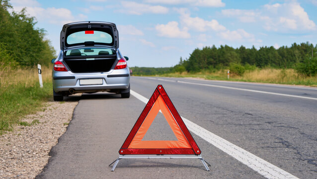 Car breakdown on rural highway, Emergency warning triangle on asphalt, Broken car with open hood, Roadside assistance concept, Vehicle failure on country road, Emergency stop on roadside