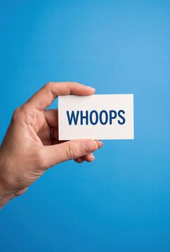 Hand holding whoops sign on blue background mistake concept