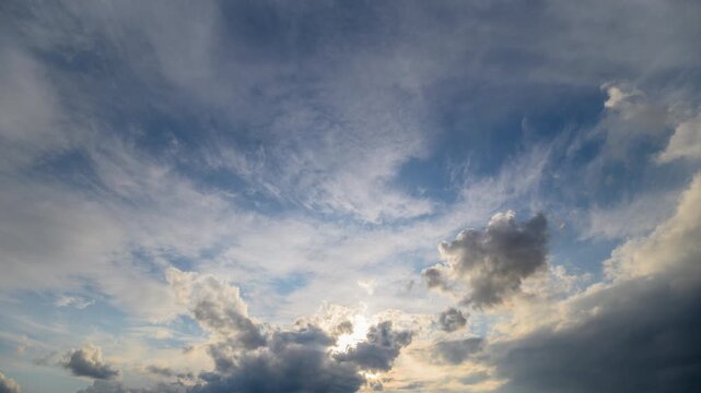 Evening sky with shifting clouds. Dramatic cloud layers under colorful sunset sky. Timelapse showing swift cloud movements beneath strikingly colorful evening horizon