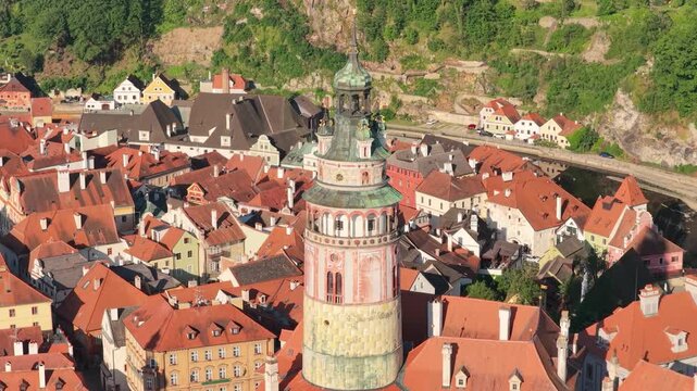 Cinematic aerial view of Cesky Krumlov historic town center at sunrise. Drone shot of beautiful medieval architecture, Vltava river, castle tower, and red roofs. Czechia, UNESCO World Heritage Site