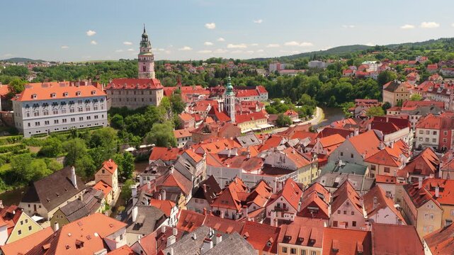 Cinematic aerial view of Cesky Krumlov historic town center. Drone shot of beautiful medieval architecture, Vltava river, castle tower, and red roofs. Czechia, UNESCO World Heritage Site