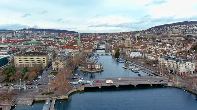 4K aerial drone footage over Zurich old town, Switzerland - Limmat River, Quaibr&uuml;cke bridge, Grossm&uuml;nster twin towers, Fraum&uuml;nster, St. Peter's Church clock tower, Altstadt, and Lake Zurich in winter.