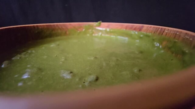"Macro close-up of a smooth, rich green Sidr (Ziziphus spina-christi) paste in a rustic wooden bowl. A perfect visual for organic hair treatments, natural beauty products, and herbal skincare concepts