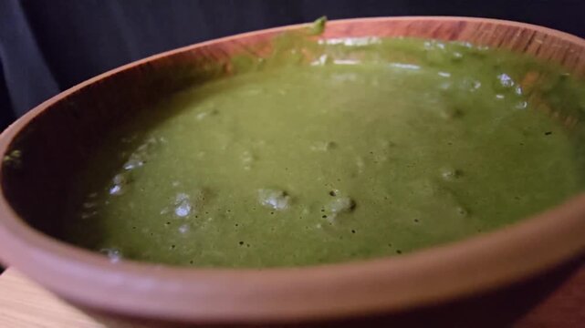 "Macro close-up of a smooth, rich green Sidr (Ziziphus spina-christi) paste in a rustic wooden bowl. A perfect visual for organic hair treatments, natural beauty products, and herbal skincare concepts