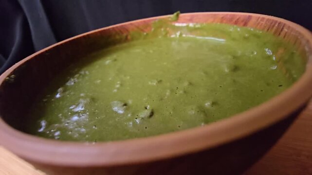 "Macro close-up of a smooth, rich green Sidr (Ziziphus spina-christi) paste in a rustic wooden bowl. A perfect visual for organic hair treatments, natural beauty products, and herbal skincare concepts