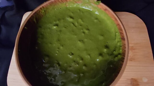 Top view of a freshly mixed, thick Sidr (Ziziphus spina-christi) herbal paste in a wooden bowl. Perfect for showcasing natural cosmetic texture and organic skincare preparation process.