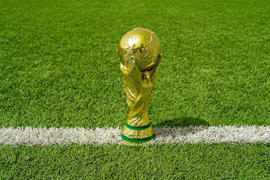 Valencia, Spain - April 10, 2026: Golden World Cup Trophy Standing On Soccer Field White Line On Green Grass with copy space
